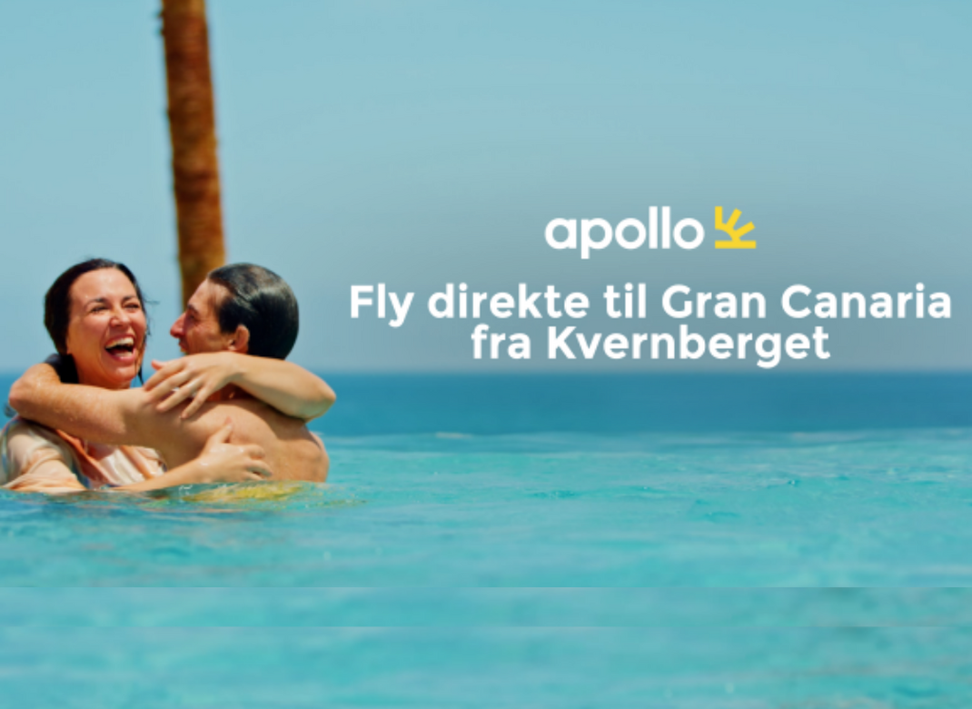 Fly direkte til Gran Canaria fra Kvernberget. En mann og en dame smiler og holder rundt hverandre mens de står i turkist vann som når dem halvveis opp til skuldrene. De har sol i ansiktene sine. I forgrunnen skimtes en palmestamme og blå, skyfri himmel.   