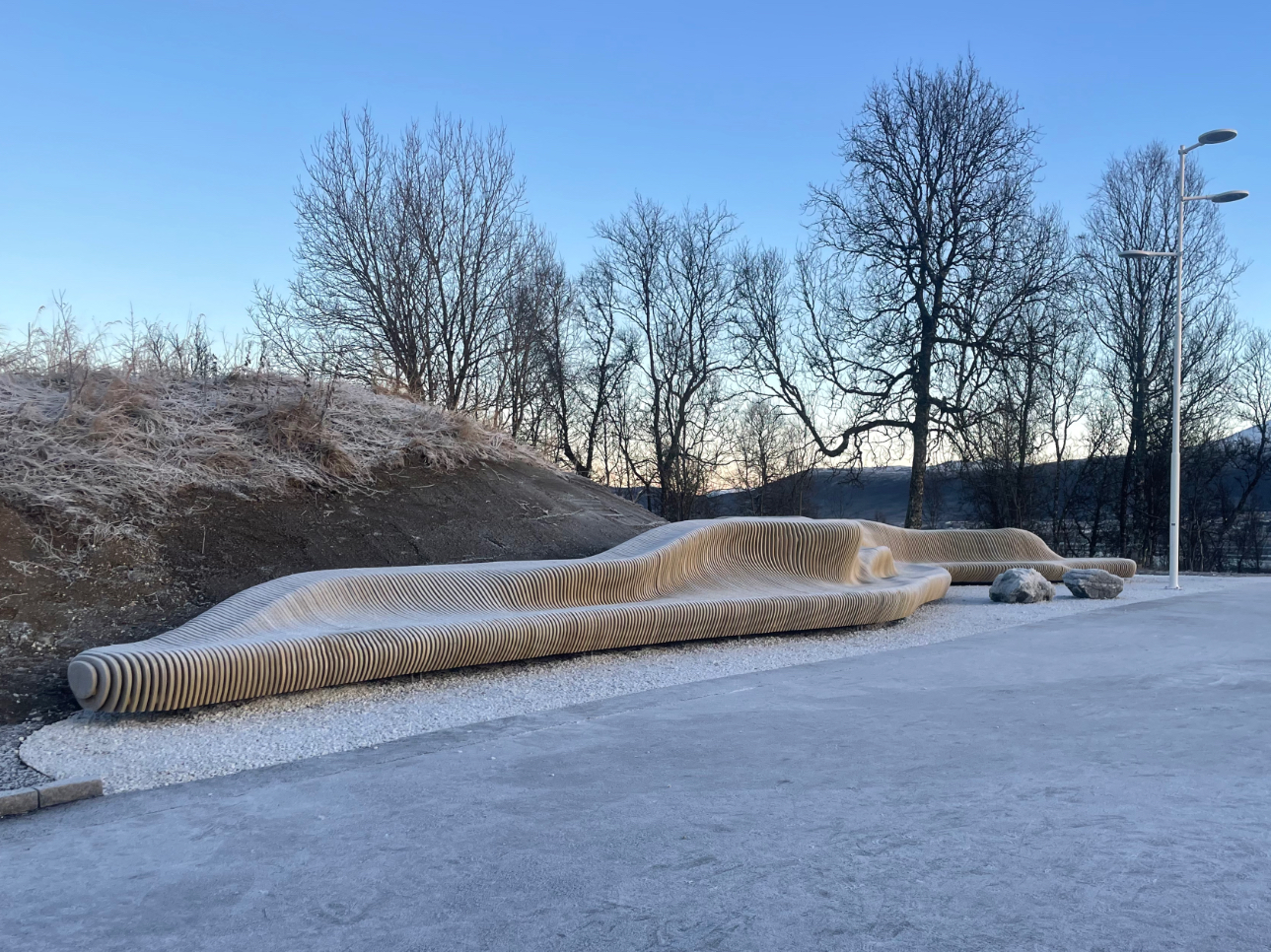 Prosjektet Community Landscape i Tromsø er tildelt Platinum Award, den høyeste utmerkelsen i sin kategori under under Architecture Madrid Awards 2025 Bildet viser prosjektet Community Landscape i Tromsø, en stor skulptur i tre, formet som et landskap. Den kan sittes på, gås på og lekes med.